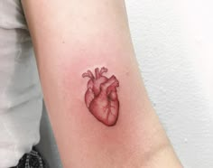 a small heart tattoo on the arm