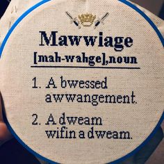 a hand holding a cross stitch pattern with words on it that read mawwage, mah - wrangle, non