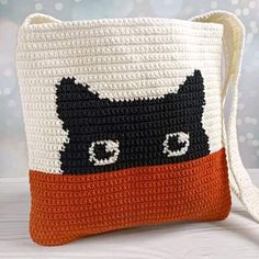 a crocheted bag with a black and white cat face on it's side