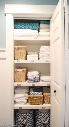 an organized closet with baskets and folded towels