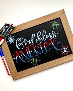 a chalkboard with the words godless america written on it next to markers and pens