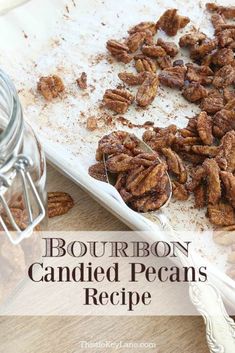 bourbon candied pecans on a cutting board next to a glass jar and spoon