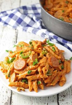 a white plate topped with pasta and sausage