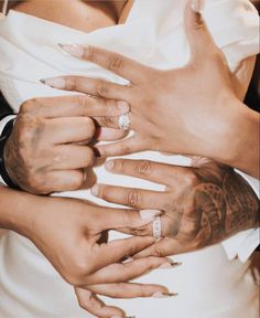 the bride and groom are holding each other's hands with tattoos on their arms