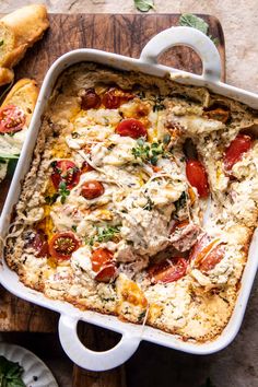 a casserole dish with chicken, tomatoes and cheese