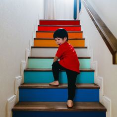 a young boy is sitting on the stairs