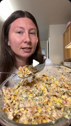 a woman holding a spoon full of food