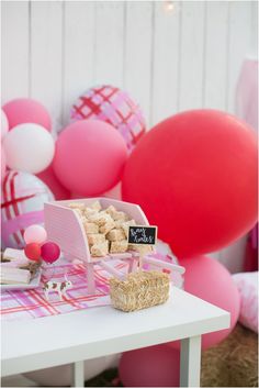 a table topped with lots of pink and white balloons