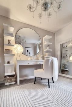 a white chair sitting in front of a mirror on top of a dresser under a chandelier