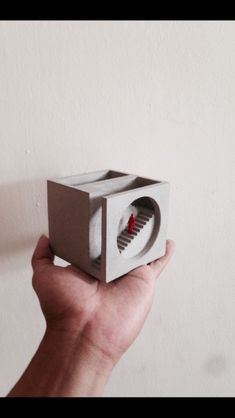 a hand holding up a small box shaped object