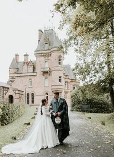 a bride and groom standing in front of a castle