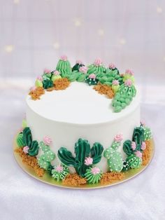 a white cake with green and pink decorations