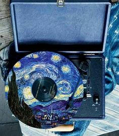 a person holding a record player in their hand with the starry night painting on it