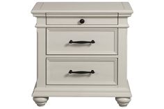 a white nightstand with two drawers and handles on it's sides, against a white background