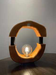 a wooden object with a light bulb in the middle on top of a wood table