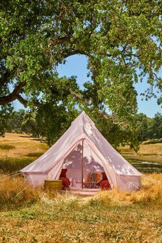 a pink tent sitting in the middle of a field