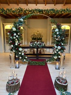 a red carpeted aisle with candles and flowers on it