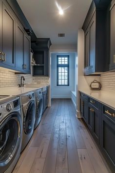 an empty laundry room with washer and dryer in the center, cabinets on both sides