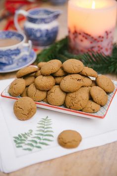 some cookies are on a plate next to a candle