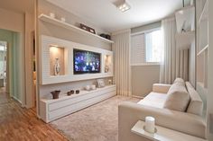 a living room filled with furniture and a flat screen tv on top of a wall