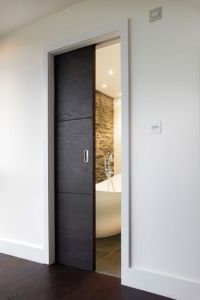 an open door leading to a bathroom with a bathtub in the corner and wood flooring