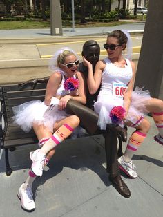 two women dressed in costumes sitting on a bench