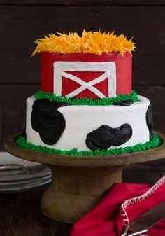 a cake decorated to look like a cow with a red and white barn on top