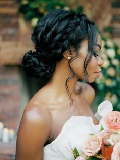 a woman in a white dress holding a bouquet of flowers and looking off into the distance