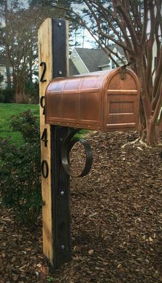 a mailbox with numbers on it in front of some trees