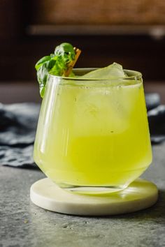 a glass filled with lemonade and garnish on top of a table