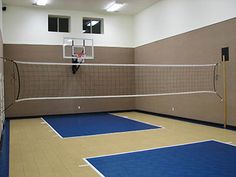 an indoor basketball court with blue and yellow flooring in the middle of two walls