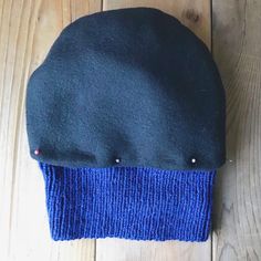 a blue and black hat laying on top of a wooden floor