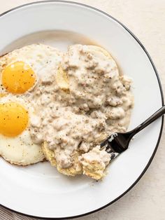 an image of eggs and gravy in a bowl with a fork on the side