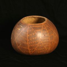 a wooden vase sitting on top of a black surface