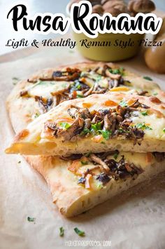 two pieces of pizza sitting on top of a piece of parchment paper next to mushrooms