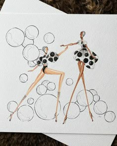 two women in black and white dresses are standing next to each other with bubbles on them