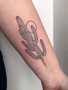 a small cactus tattoo on the arm