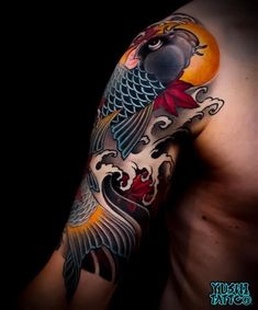 a man's arm with a bird and flowers tattoo design on the left arm