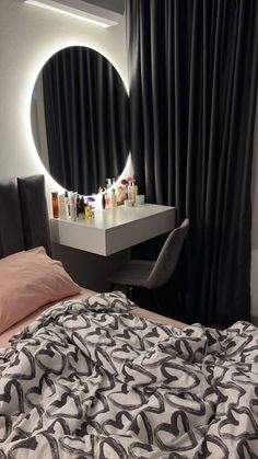 a bedroom with a bed, desk and round mirror on the wall above it's headboard