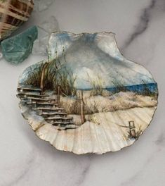 a seashell with a painting on it sitting on a table