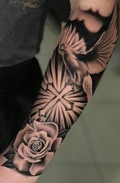 a man with a cross and rose tattoo on his arm