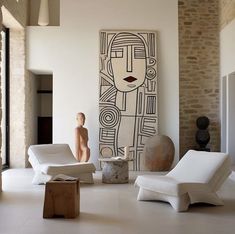 a living room filled with white furniture and art