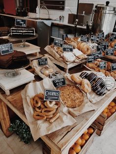 an assortment of baked goods displayed on wooden trays in a bakery setting with price signs