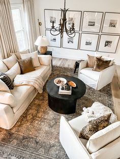 a living room filled with furniture and pictures on the wall