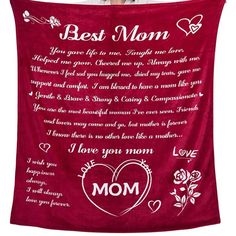 a woman holding up a red blanket with the words best mom on it