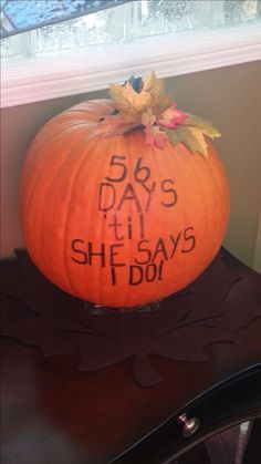 a pumpkin with writing on it sitting on a table next to a window sill