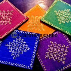 four colorful coasters with designs on them sitting on top of a wooden table next to each other