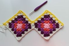 a crocheted square with two different colored squares on it and a knitting needle next to it