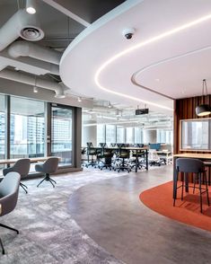 an office with chairs, tables and desks in the middle of it's large room