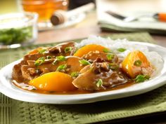 a close up of a plate of food with rice and oranges on the side